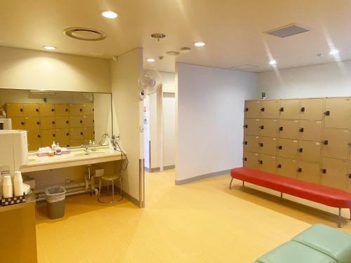 幕别町十胜娜芒温泉酒店的浴室设有水槽和红色长凳