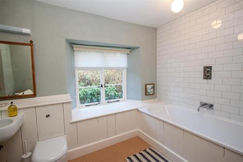 彭里斯Thomas Grove House的带浴缸、水槽和窗户的浴室