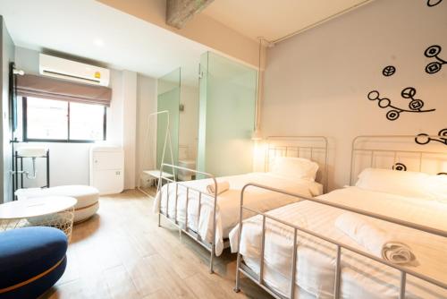 曼谷贝德普勒蒂旅舍的配有镜子的客房内的两张床