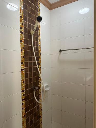 Nong Khaeโรงแรมกู๊ดเรสซิเดนซ์ - Good Residence的浴室内带软管的淋浴