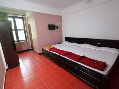 苏丹巴特利Tapovan Farm House的一间卧室配有一张带红色毯子的大床
