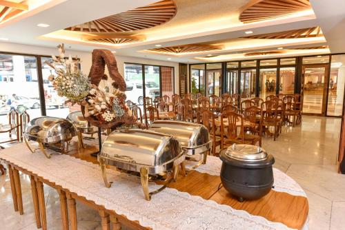 马尼拉Kabayan Hotel Pasay的一间带桌椅的用餐室和一间带窗户的房间