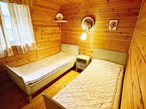 KyrpingThree-Bedroom Holiday home in Åkra的小木屋内一间卧室,配有两张床