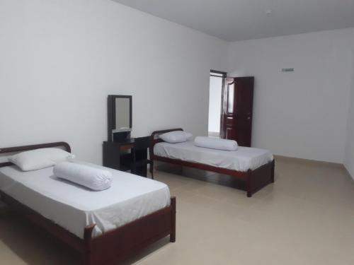巴淡岛中心HAPDESKO HOMESTAY的白色墙壁客房的两张床