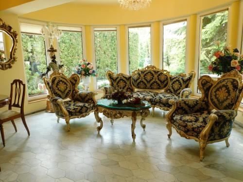 莫雄马扎尔古堡全景酒店的客厅配有椅子和桌子,设有窗户