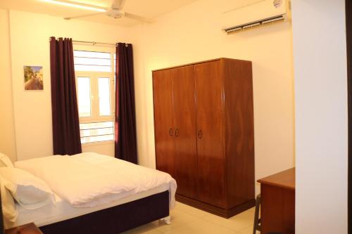 锡卜Al-Mwadda Hotel的一间卧室配有一张床和一个木制橱柜