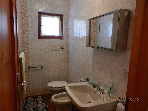 博尔米奥Appartamento con splendida vista su pista Stelvio的一间带水槽和卫生间的浴室以及窗户。