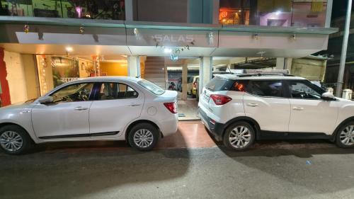 马哈巴莱斯赫瓦尔SALAS EXECUTIVE的两辆白色汽车停在大楼前