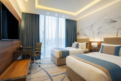 吉达CHARLI Hotel Jeddah的酒店客房设有两张床和电视。