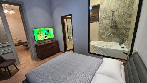 库塔伊西Nino's Cosy Apartment的一间卧室配有一张床、一个浴缸和一台电视。