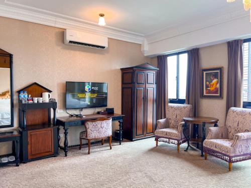 草屯镇宝旺莱6号花园酒店的客厅配有电视、书桌和椅子