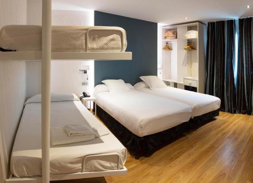 塞维利亚塞维利亚贝拉维斯塔酒店的铺有木地板的客房内配有两张双层床。
