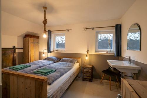 阿纳姆Vakantiehuisje aan de rand van Arnhem的一间卧室设有一张大床和一个水槽