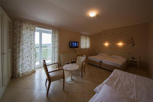 多博沃Hotel Kozana的一间卧室配有两张床和一张桌子及椅子