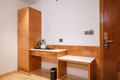 科钦Townbridge Hotels & Suites的一个带水槽和木门的小厨房