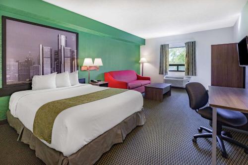 温莎温莎大使桥速8汽车旅馆的酒店客房设有一张大床和一张书桌。