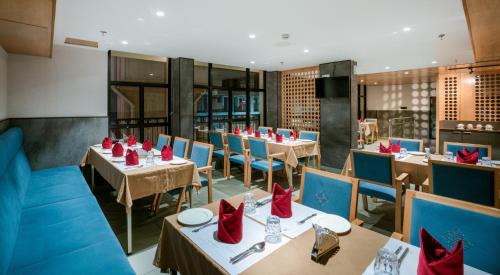 科钦Townbridge Hotels & Suites的餐厅配有桌椅和红色餐巾