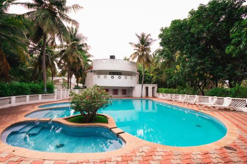 马哈巴利普拉姆Shelter Beach Resort的一座游泳池,其建筑背景为: