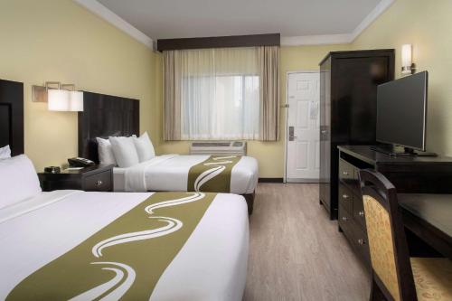 盖洛普Quality Inn & Suites Gallup I-40 Exit 20的酒店客房设有两张床和一台平面电视。