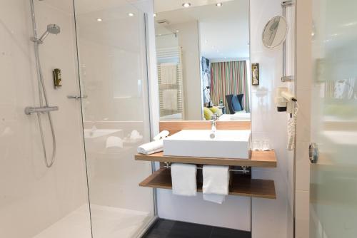 萨尔布吕肯Hotel Am Triller - Hotel & Serviced Apartments的一间带水槽和淋浴的浴室