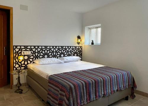 萨各夫雷纳Las Tres Hermanas的一间卧室配有一张带毯子的床和窗户