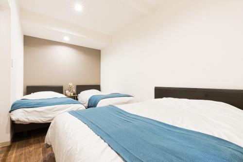 东京Mita Guest house - Vacation STAY 12100的白色和蓝色的客房内的两张床