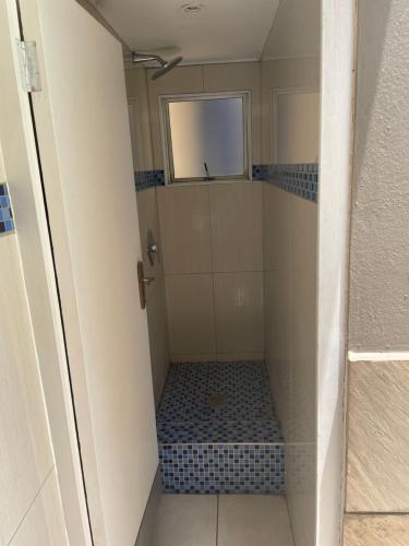 德班Oceanic View的一间铺有蓝色瓷砖的带淋浴的小浴室