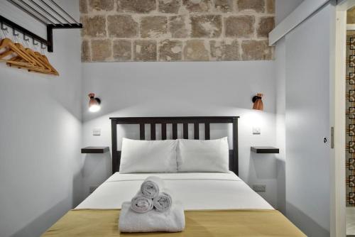 瓦莱塔Vallettastay Old Lodge Studio 5的一间卧室配有带毛巾的床