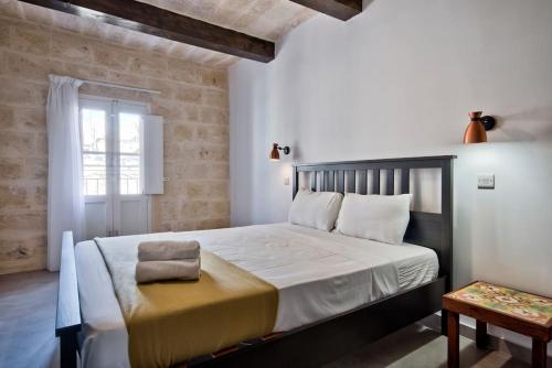 瓦莱塔Vallettastay Old Lodge Apartment 7的一间卧室设有一张大床和一个窗户。