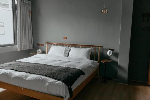花莲市畔居民宿的一间卧室配有一张带白色床单的大床