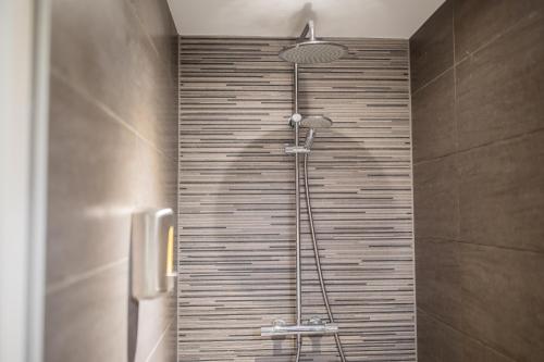 蒂尔Great 95m² Two-Bedroom Apartment的带淋浴的浴室(带瓷砖墙)