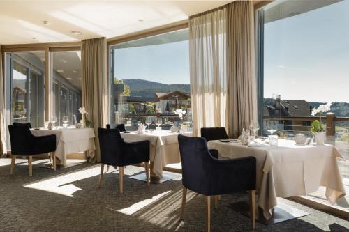 阿维兰奥米拉贝尔小屋酒店的餐厅设有桌椅和大窗户。