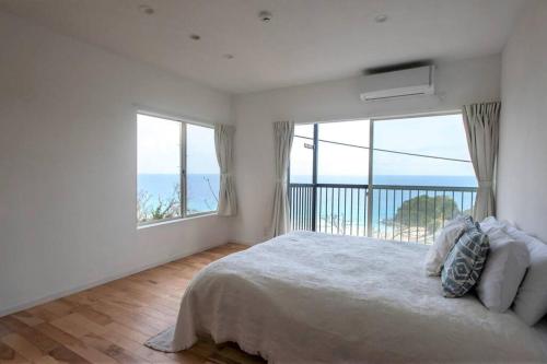下田Sirahama Beach House的一间卧室设有一张大床和一个大窗户