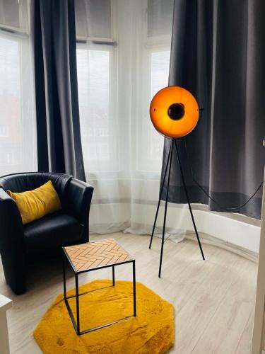 不来梅港不来梅港城市膳食公寓酒店的客厅里的一个橙色灯,配有沙发