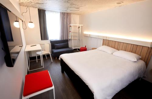 欧塞尔ibis Auxerre Centre的酒店客房配有一张床、一把椅子和一张书桌