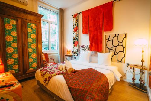 盖布维莱尔Domaine Bohème I art de vivre的一间设有床铺的卧室,位于一间设有红色窗帘的房间