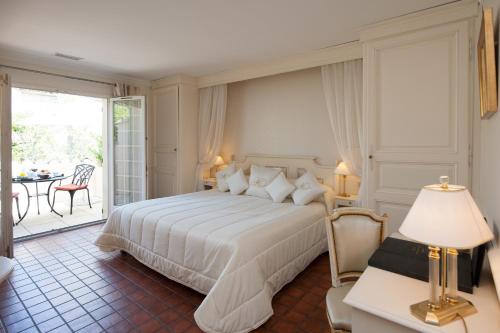 莱蓬特奥贝奇温泉酒店的卧室设有一张白色大床和一个庭院。