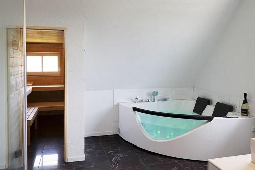 Gemeinde AichhaldenSchwarzwaldhaus24 - Ferienhaus mit Sauna, Whirlpool und Kamin的白色的浴室设有浴缸和水槽。