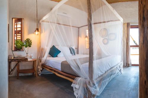 路易斯科雷亚Beekite Wind Village的一间卧室配有带蚊帐的天蓬床。