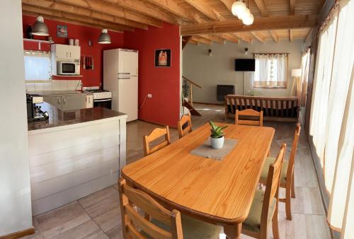 圣卡洛斯-德巴里洛切Hermosa y confortable casita en Bariloche的厨房以及带木桌和椅子的用餐室。