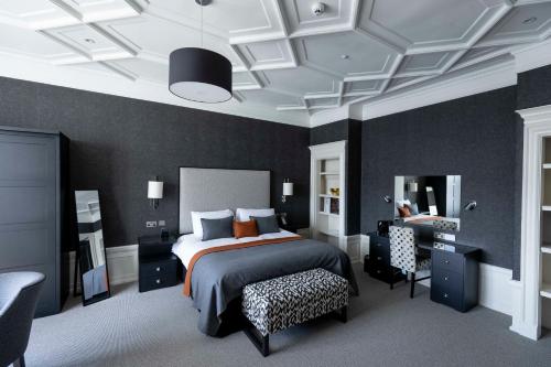 阿伯丁切斯特酒店的一间卧室配有一张床、一张桌子和一把椅子