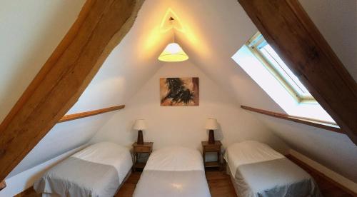 吕村Camping La Garenne De Moncourt的两张床位于房子的阁楼