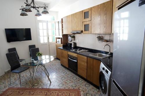 得土安Tetouan Luxury Apartment的厨房配有水槽、冰箱和桌子