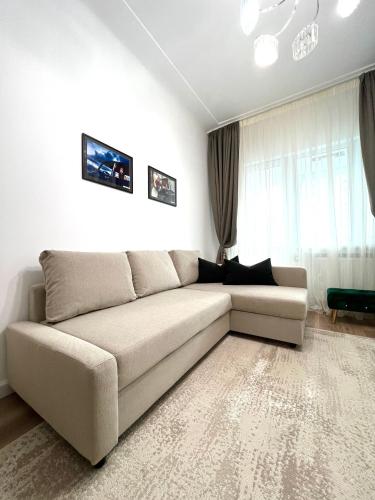 布加勒斯特Sky View - Luxury Apartament - Sanador Victoriei的客厅的窗户前设有沙发