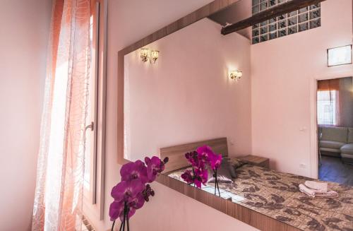 穆拉诺Ca' Laura - Murano Centro的花瓶里紫色花的镜子
