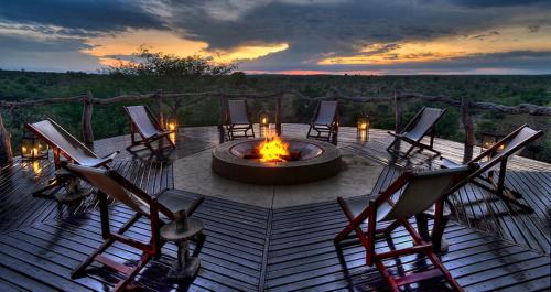 克拉塞利尔自然保护区Makumu Private Game Lodge的坐在火坑周围的椅子