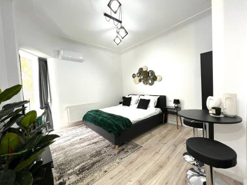 布加勒斯特Green Spot - Premium Studio - Sanador Victoriei的卧室配有一张床和一张桌子及椅子