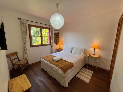 拉塞雷纳El Arbol Hostel的一间卧室设有床、两张桌子和一扇窗户