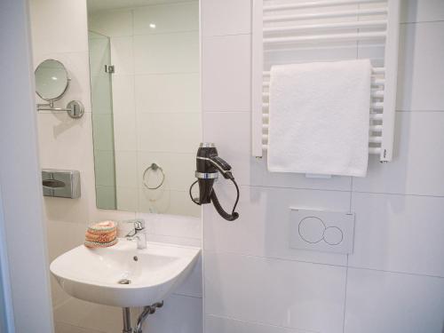 鲁尔河畔米尔海姆Tante ALMA's Mülheimer Hotel的白色的浴室设有水槽和镜子