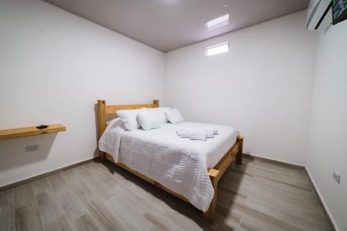 卡利Hotel Alameda Plaza的一间卧室配有一张铺有木地板的白色床单。